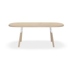 Vooraanzicht Licht eiken tafel Table Talk van Bert Plantagie  met ronde hoeken, schuingeplaatste ronde tafelpoten waarvan onderkant licht eiken en bovenkant wit.