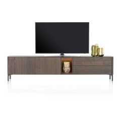 Lowboard TRENTON in claykleur, 240 cm breed, met latjesmotief, ledverlichte niche en metalen onderstel, gepresenteerd met een tv en decoratie.