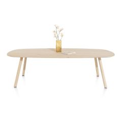 Vooraanzicht van eetkamertafel Niora met licht eikenfineer blad en slanke houten poten, gedecoreerd met een vaas met bloemen, minimalistisch en modern design.