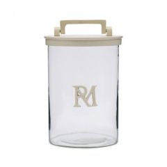 Close-up van een Riviera Maison voorraadpot met monogram, met een glazen lichaam en een beige deksel met handgreep.