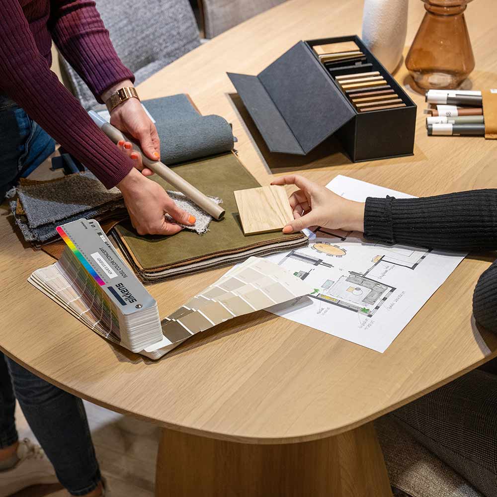 Interieuradvies sessie bij Home Center met kleurstalen, stoffen en een interieurontwerp op tafel